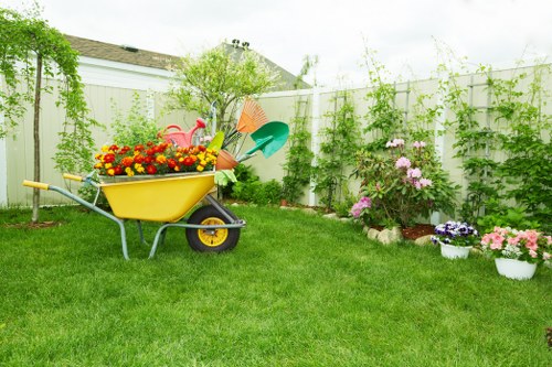 Garden maintenance crew clearing overgrown beds in a suburban Hatch End yard